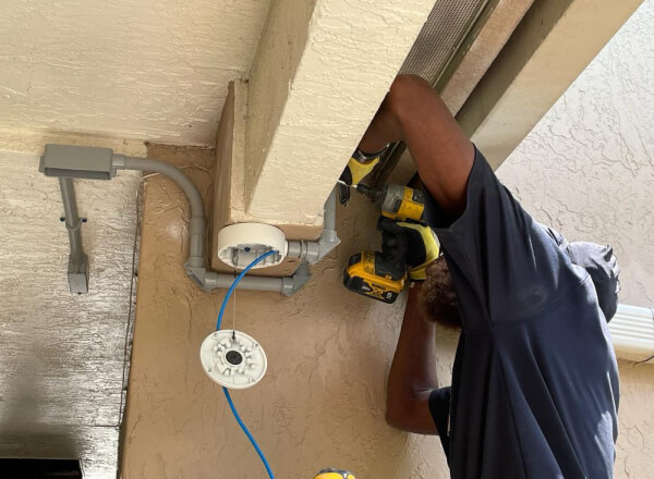 Technician installing a security system at a Dallas school