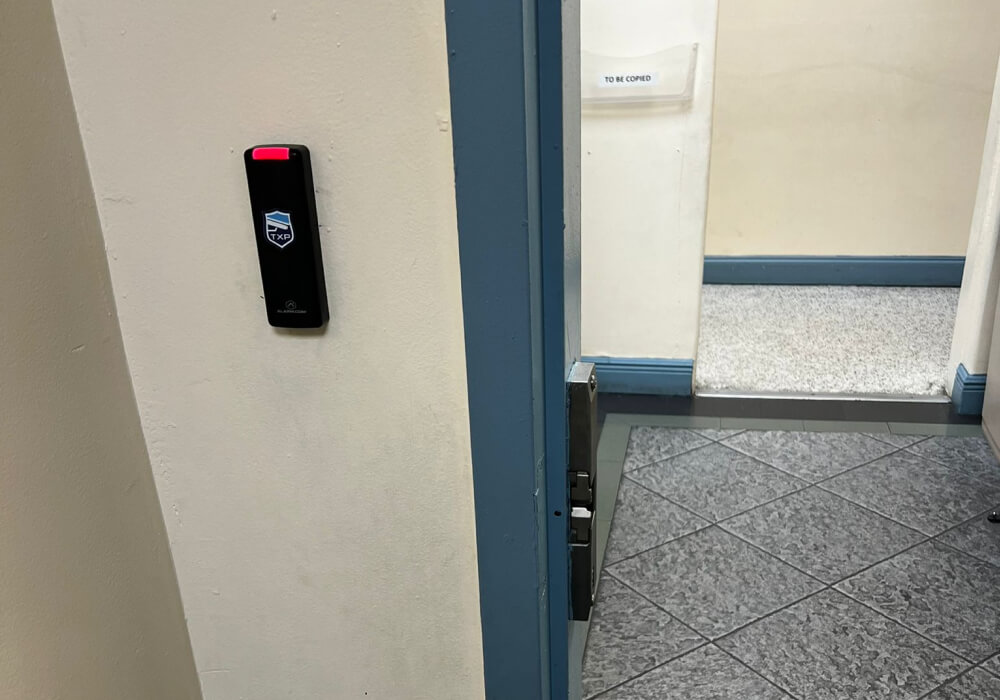 Access control card reader mounted beside a secured commercial door