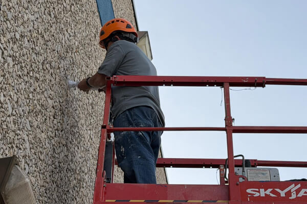 Commercial security camera installation in Austin, technician mounting exterior camera
