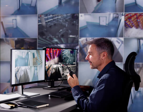 Operator reviewing live video monitoring feeds at a central station
