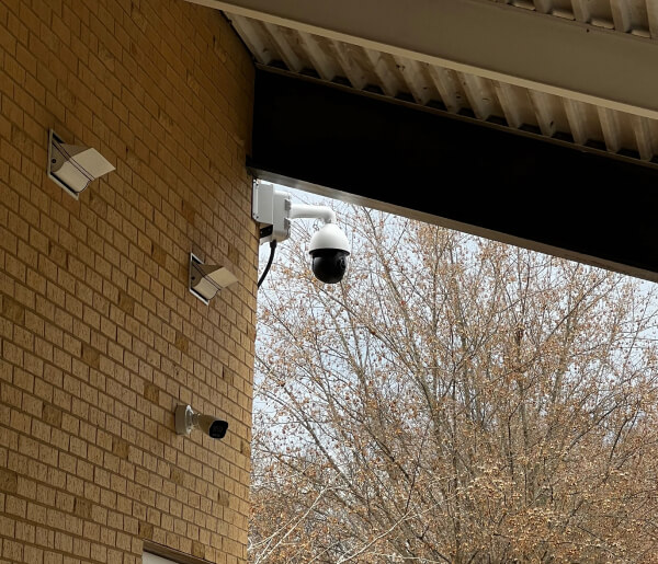 Security cameras covering a synagogue walkway and parking area